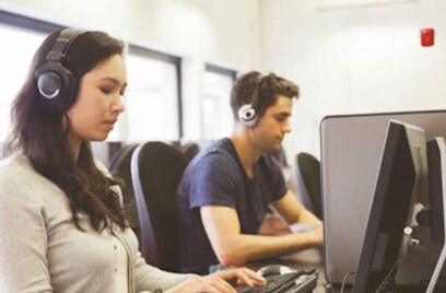 Two people working on computers in office