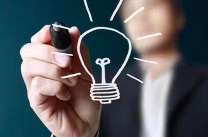 Man drawing a lightbulb on glass surface