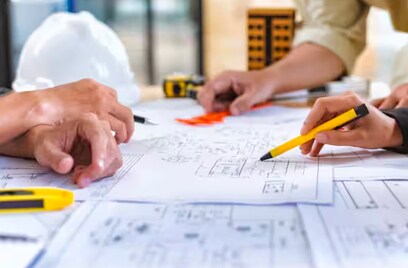 Close-up of people examining blueprints