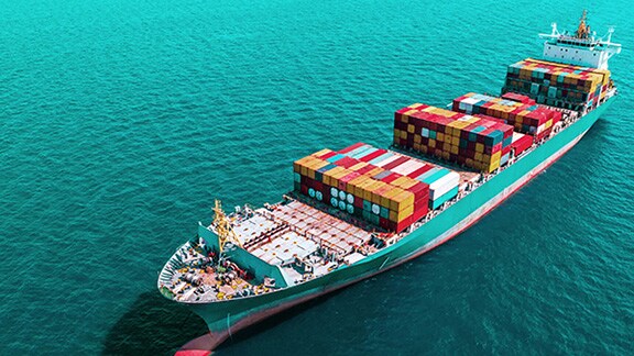 A ship with storage containers in the open sea