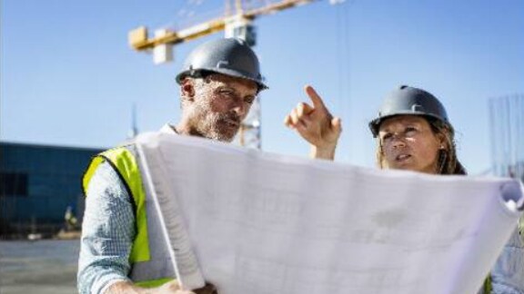 Two workers looking chart