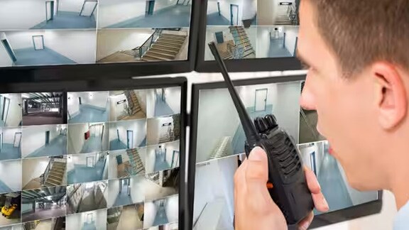 Security personnel monitoring video surveillance footages in a control room