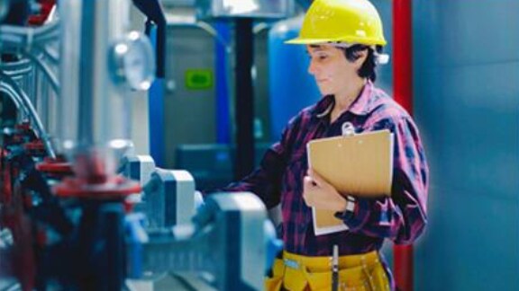 Yellow helmet worker operating machines