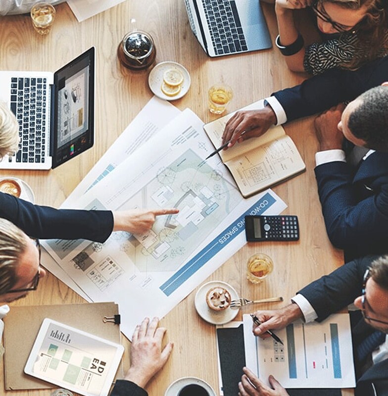 overhead view of people analyzing a chart in a conference room