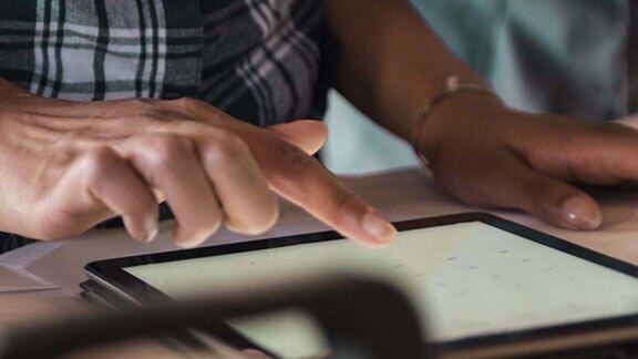 person operating tablet on table