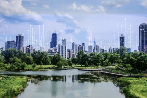 An urban cityscape by a water body at daytime, overlaid with OpenBlue graphics