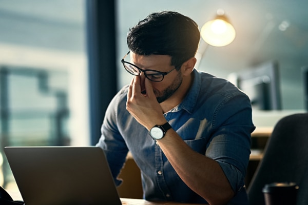 A man working on laptop stressed due to work