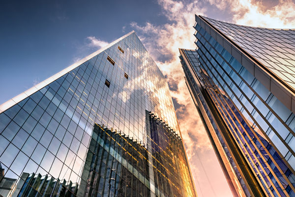 An upward shot of two skyscrapers on a cloudy day